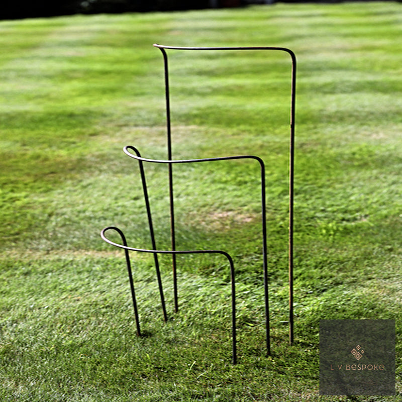 Four LV Bespoke curved steel plant supports in graduated sizes on a striped lawn