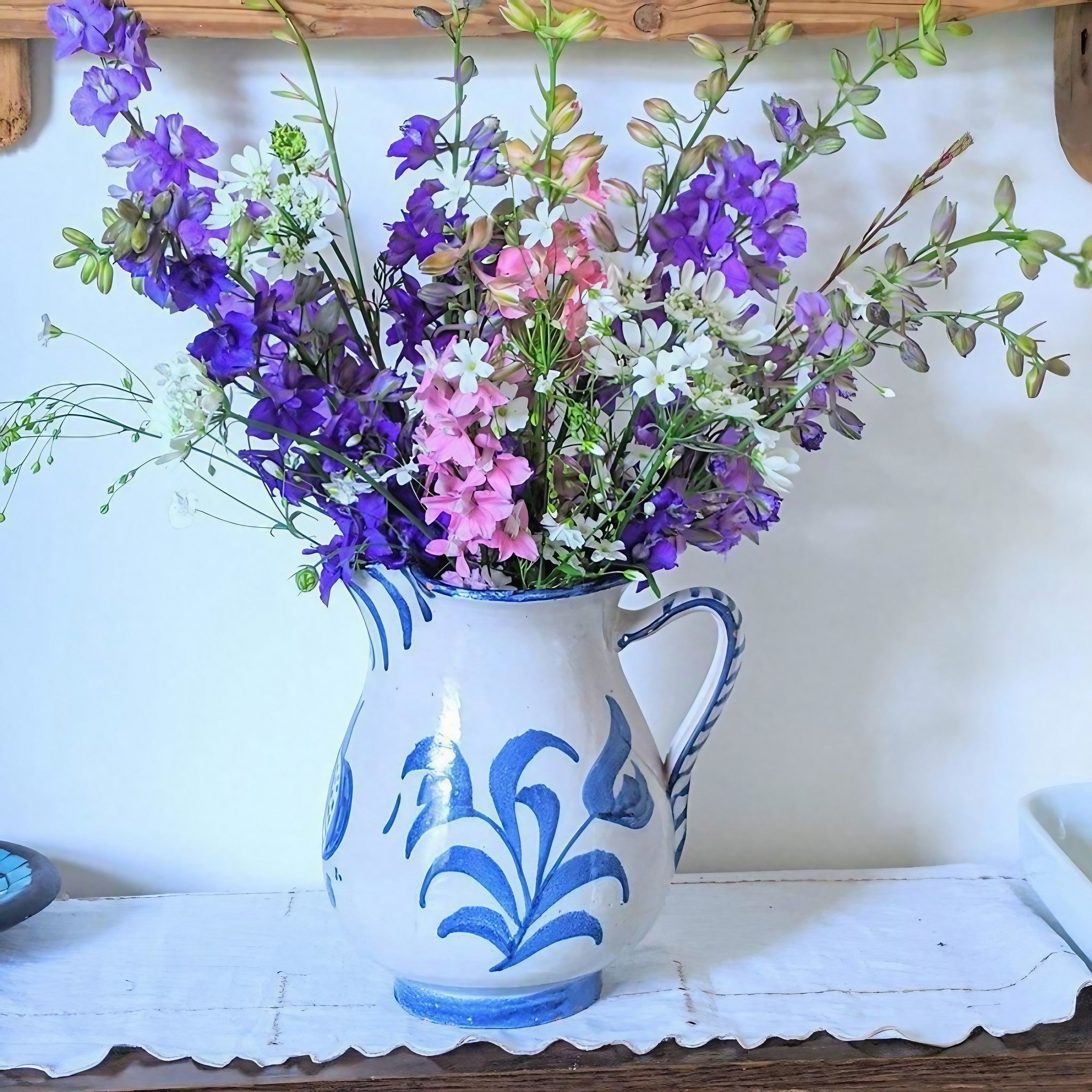 Larkspur Giant Imperial Mix flowers displayed in a blue and white ceramic pitcher