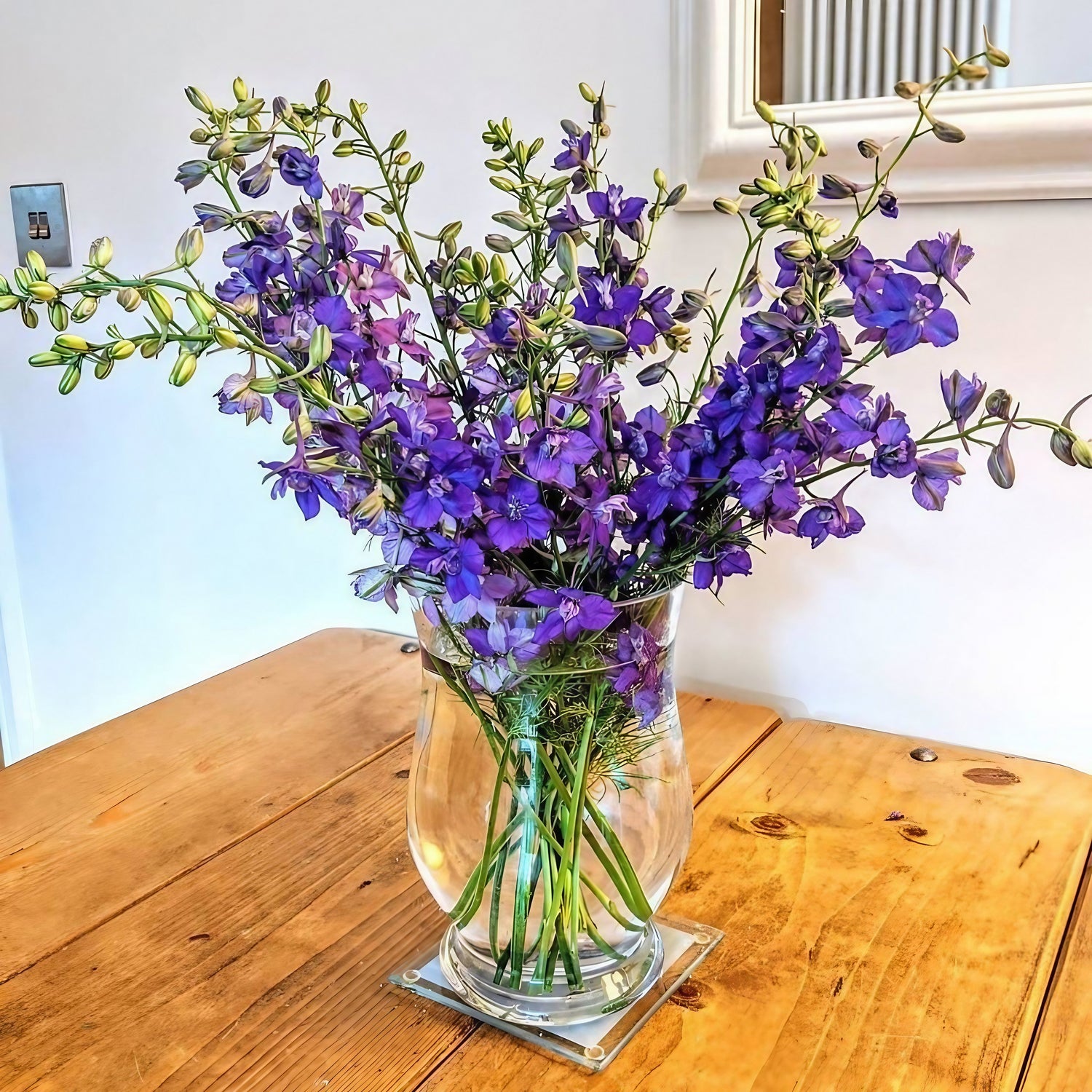 A bouquet of Larkspur Giant Imperial Mix flowers arranged in a vase on a table
