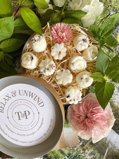 Relax &amp; Unwind essential oil wax melts arranged in a floral setting with bergamot, lavender, and lemongrass scents.