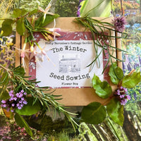 The Winter Seed Sowing Flower Box by Bishy Barnabees Cottage Garden is shown with fresh green leaves and flowers, set atop vibrant garden photos—ideal for winter sowing and simple seed stratification.