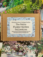 A cardboard box labeled The Patio Flower Garden Collection by Bishy Barnabees Cottage Garden, ideal for container flower seeds, is surrounded by colorful garden and flower photos.
