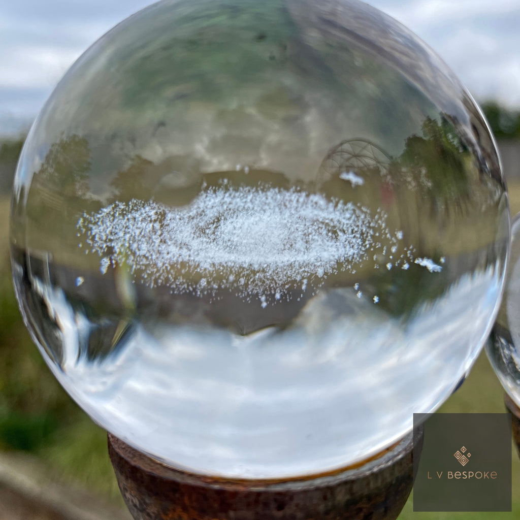 Close-up of a 3D orb garden stake with a laser-etched spiral galaxy inside the crystal sphere