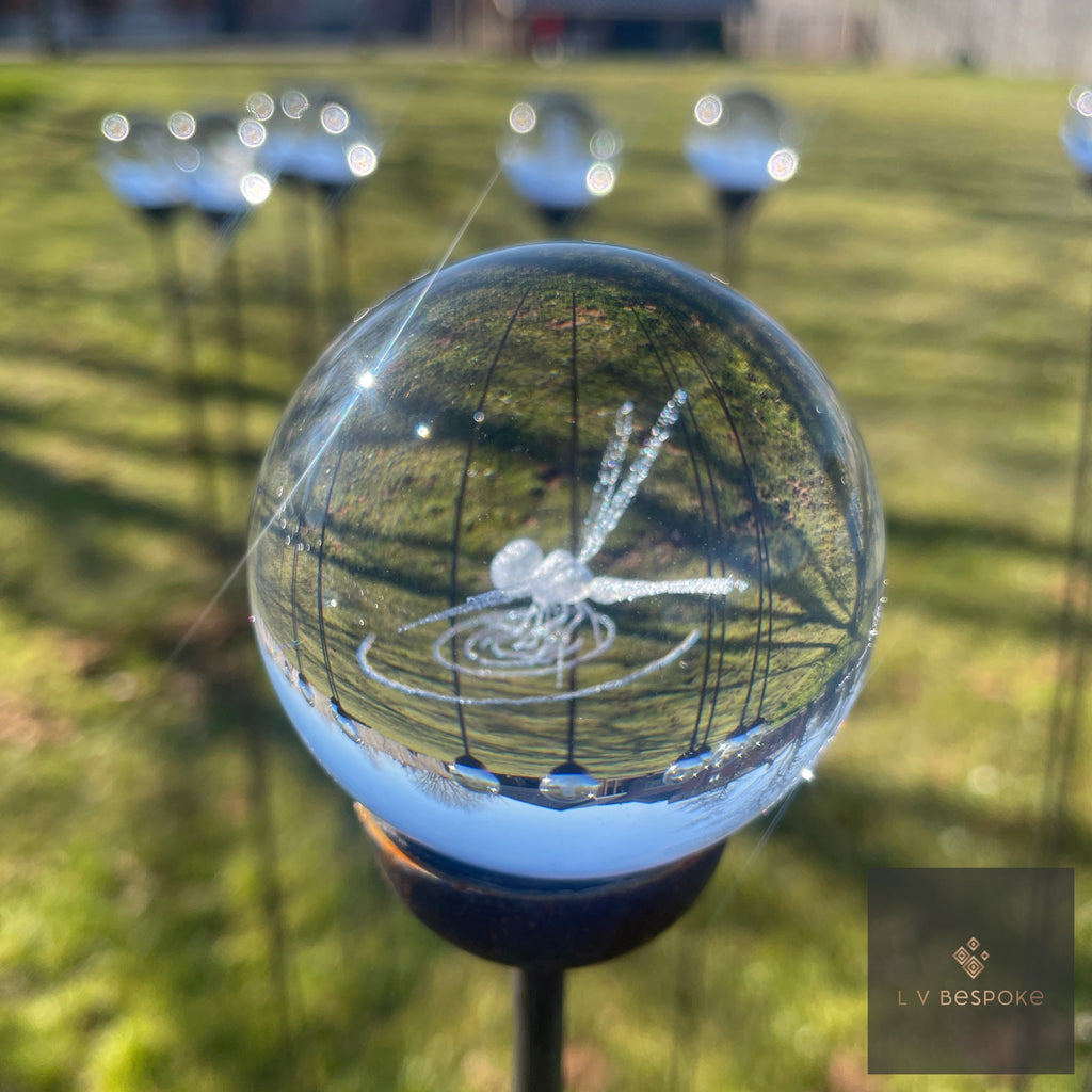 3D orb garden stake with an etched dragonfly, other orbs on the lawn behind