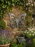 Metal butterfly wall art on a garden wall with ivy and lavender