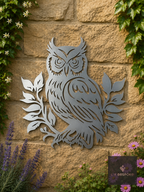 Metal owl on a branch wall art on a stone wall with ivy