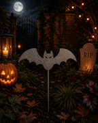 Metal bat garden stake in a spooky Halloween garden with pumpkins