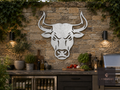 Metal bull head wall art on a stone wall in an outdoor kitchen