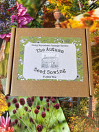 A cardboard box labeled "Bishy Barnabees Cottage Garden The Autumn Seed Sowing Flower Box" rests atop vibrant garden photos, offering hardy annuals perfect for your cutting flower patch.