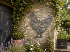 Geometric metal hen wall art on a stone wall beside a shed