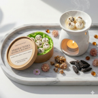 A marble tray displays Tadpole & Piglet’s Myrrh & Tonka Botanical Wax Melts, featuring flower-shaped hand-poured melts in a round box, a white wax warmer, dried flowers, myrrh resin, and tonka beans.