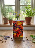 The Chilli Rainbow Greeting Card by Bishy Barnabees Cottage Garden Ltd features assorted peppers on a colorful box, ideal as a gardener’s gift or chilli greeting, displayed on a wooden table with dried flowers and potted plants nearby.
