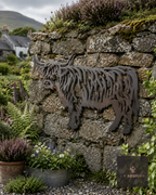 Metal Highland cow wall art on a dry stone wall