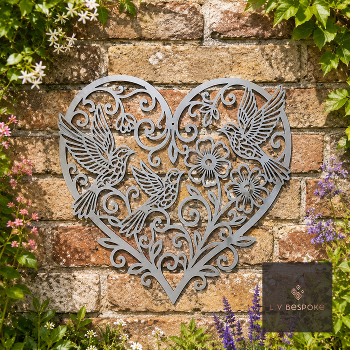 Metal heart wall art with hummingbirds and flowers on a brick wall