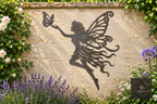 Metal fairy with a butterfly wall art on a garden wall