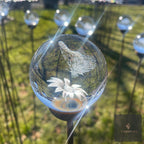 3D orb garden stake with crystal-effect sphere catching the light in a flower border