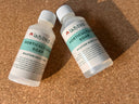 Two bottles of Horticultural Soap by ladybirdplantcare.co.uk rest on a cork surface. Each features a white cap and green label showing "Dilution Rate 1:100" along with product information.