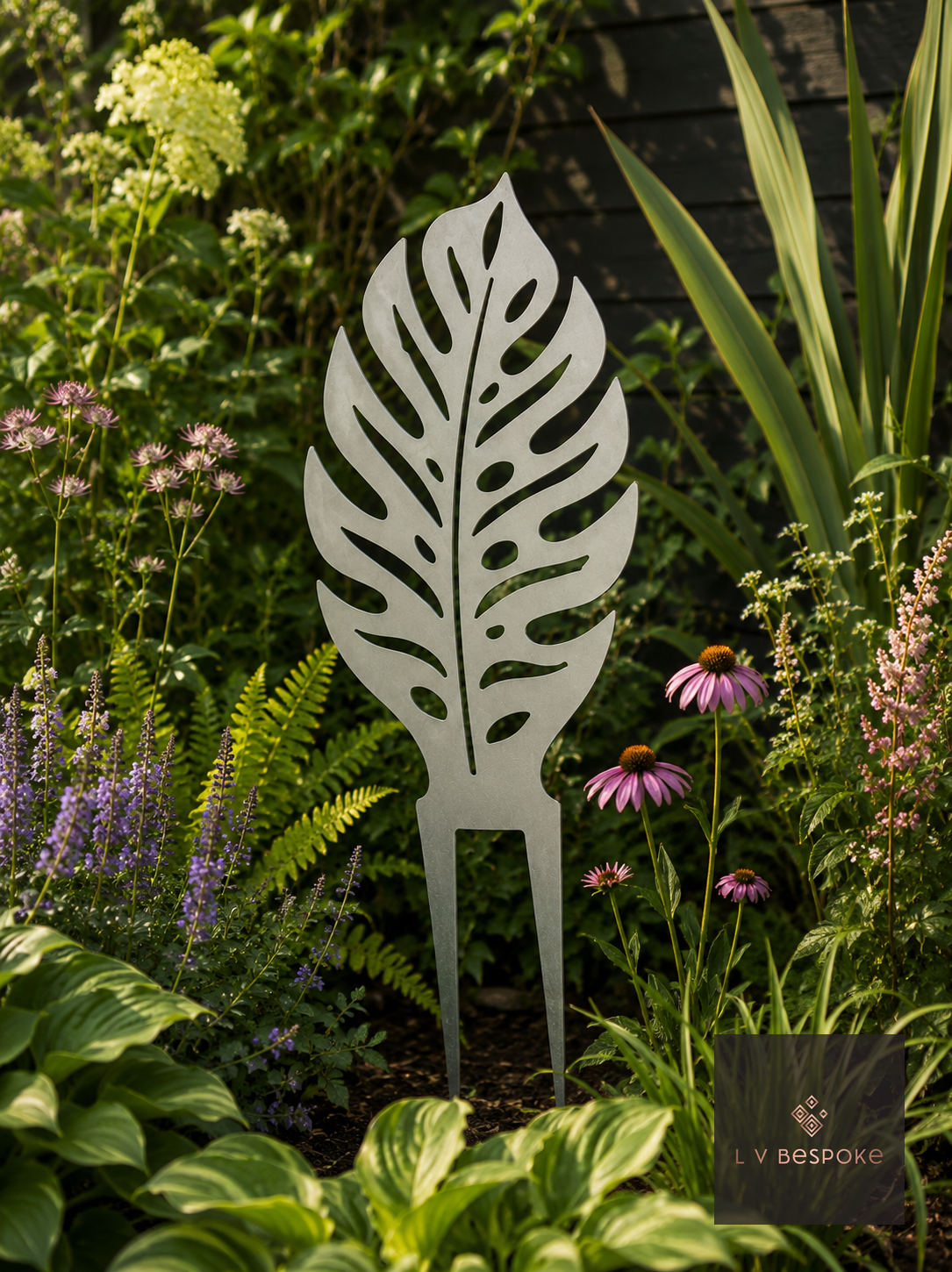 Metal leaf garden stake among echinacea and hostas