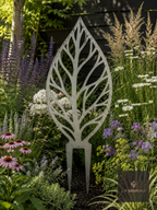 Metal leaf-outline garden stake in a flower border