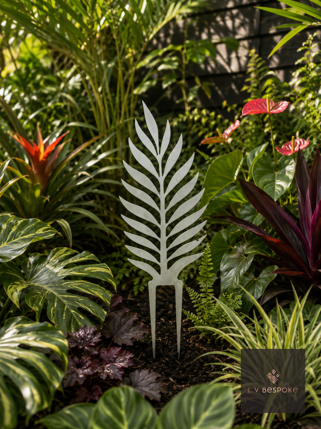 Metal palm-leaf garden stake among tropical plants