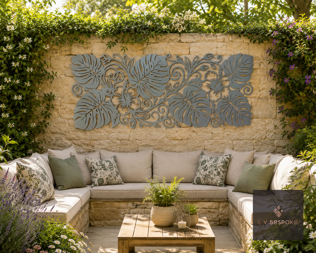Metal leaf-pattern wall art above an outdoor sofa on a garden patio