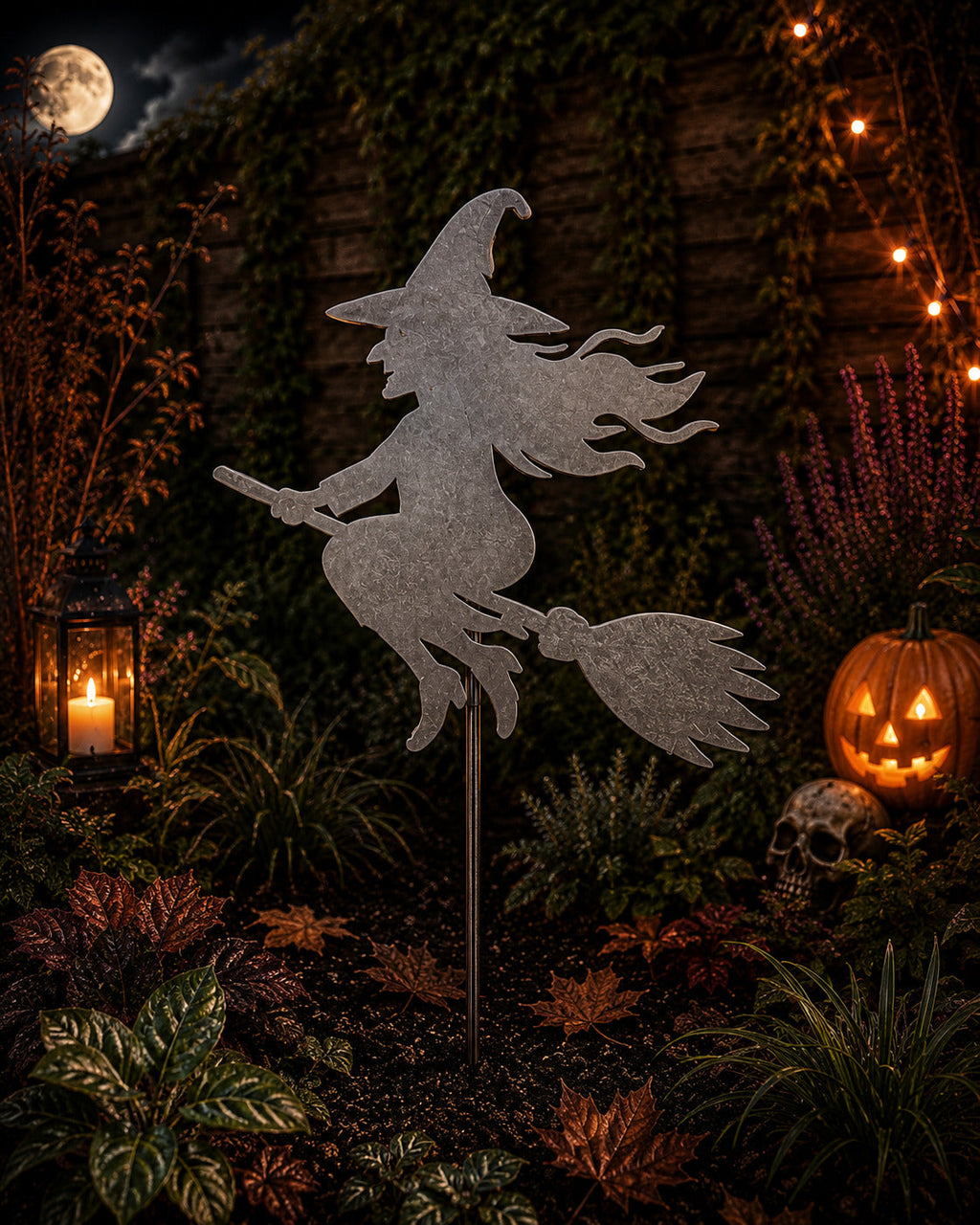 Metal witch on a broomstick garden stake in a Halloween scene