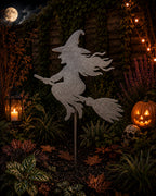 Metal witch on a broomstick garden stake in a Halloween scene