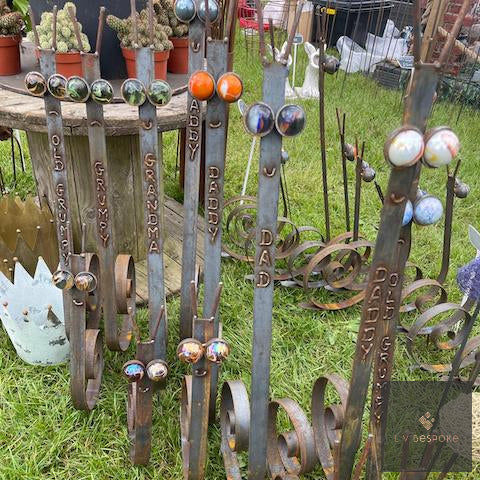 Group of steel snail stakes with assorted marble eyes on a show stand