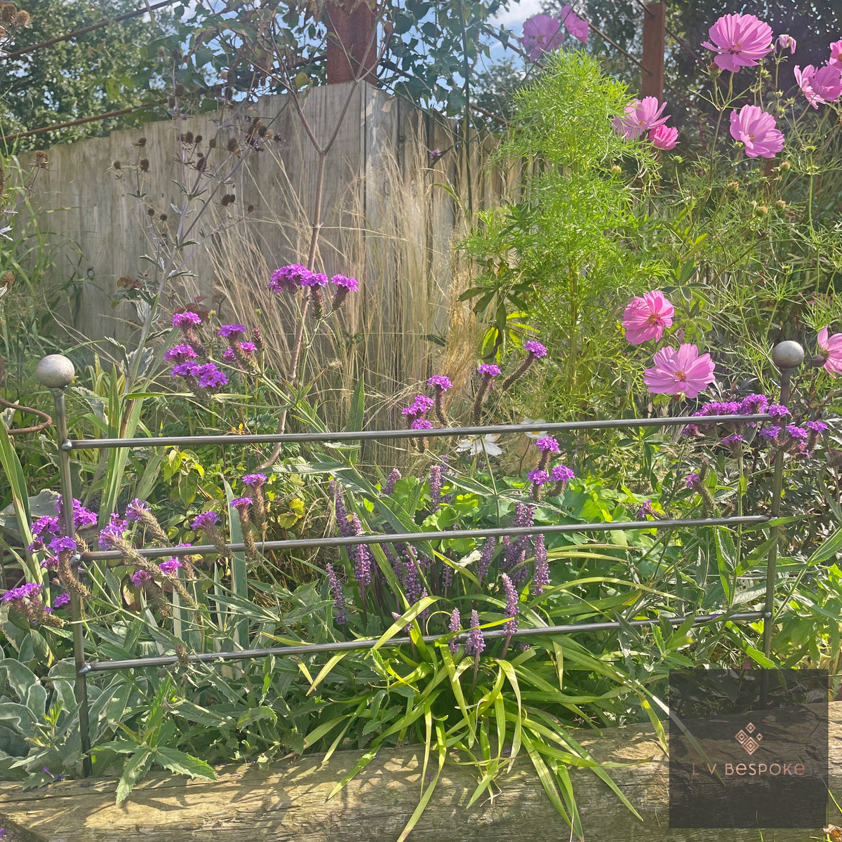 Victorian style raw steel border edging in front of verbena and phlox