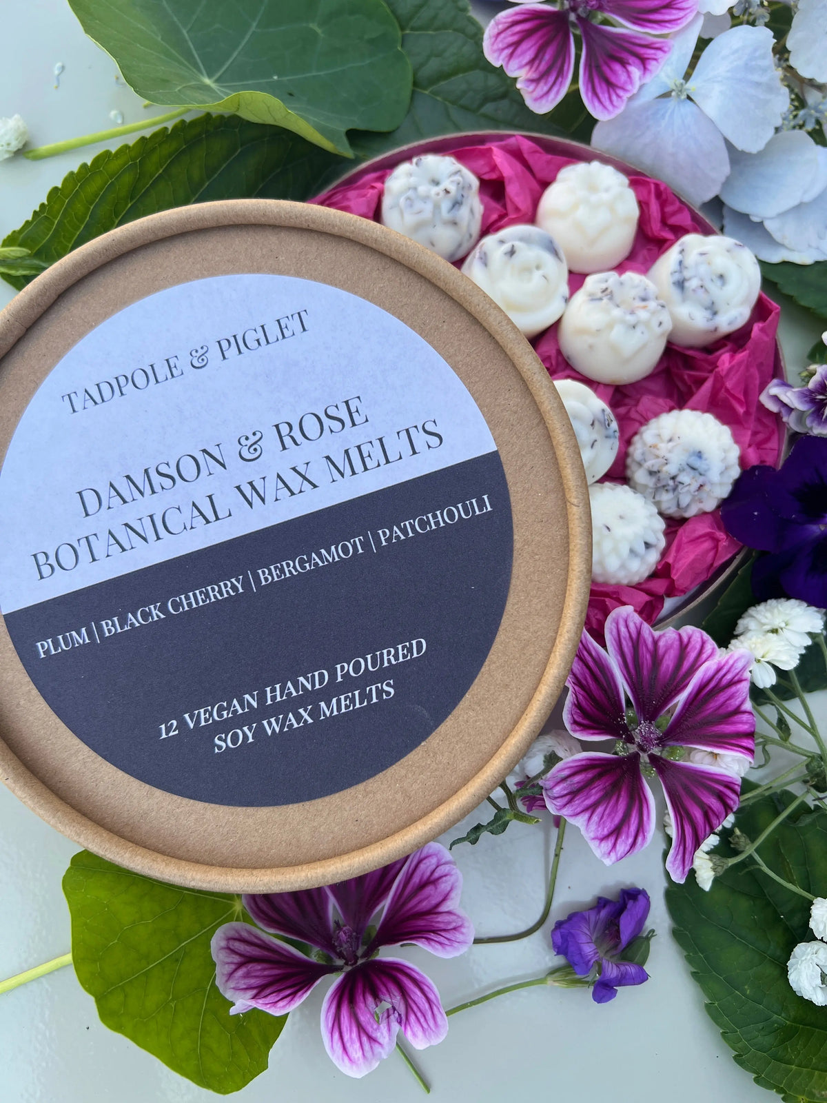 Damson & Rose Botanical Wax Melts – open box of melts with dried botanicals among flowers