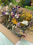 Dried Flower Craft Box of yellow, purple, white and pink blooms on a weathered green surface