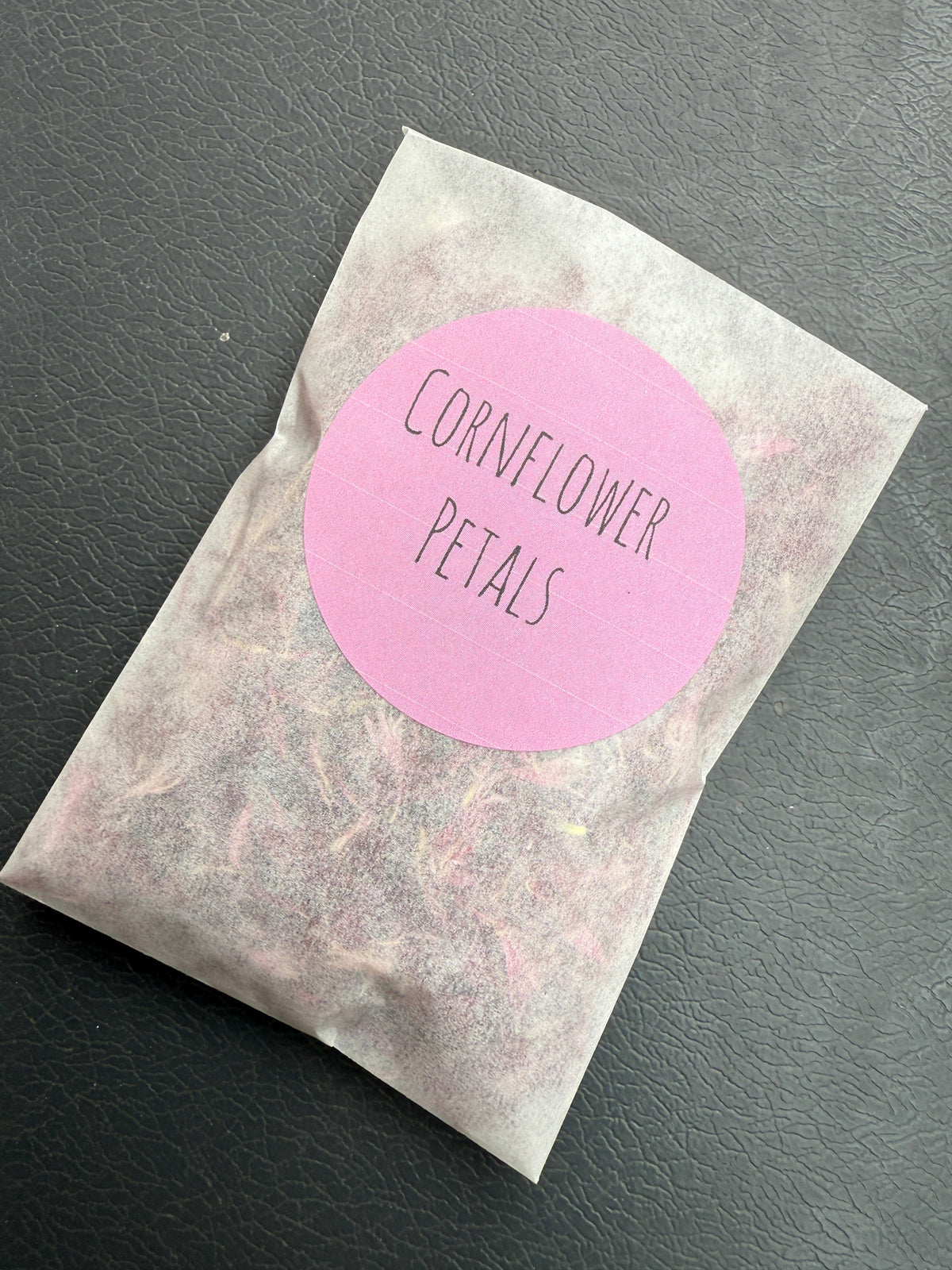 Dried Flower Petals – bag with a pink Cornflower Petals label on dark slate