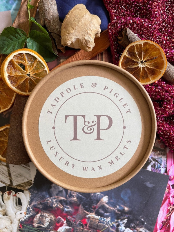 The Festive Spice Botanical Wax Melts logo displayed on a wooden surface
