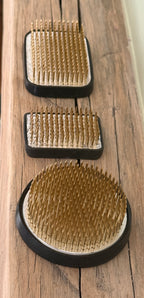 Kenzan Flower Frogs in three sizes seen from above on a wooden board