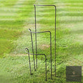 Set of metal half-hoop plant supports standing on a striped lawn