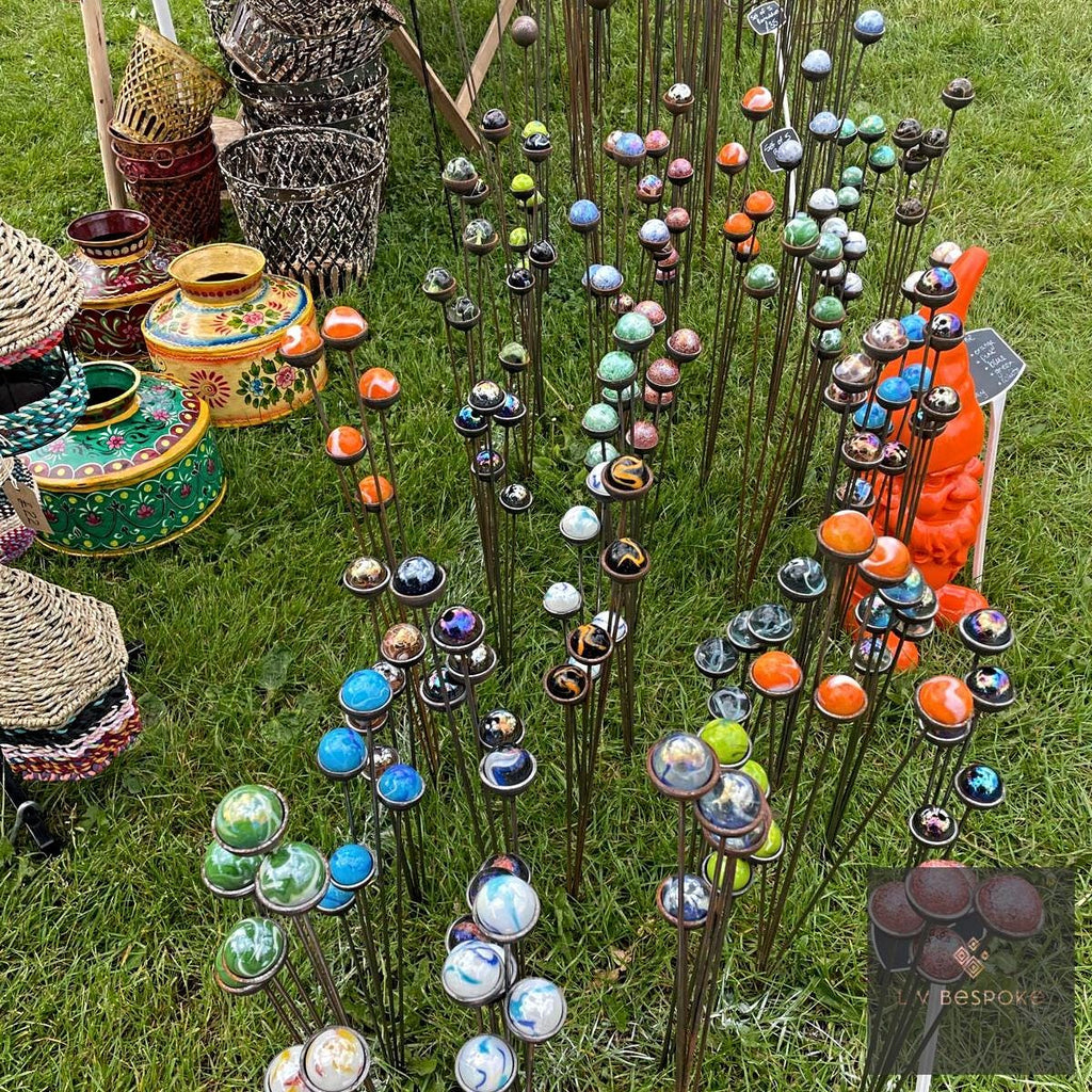 Rows of glass ball garden stakes in many colours