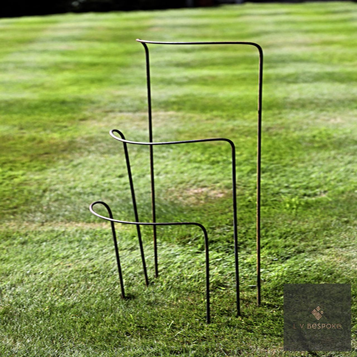 Metal half-hoop plant supports in three heights on a lawn