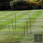 Metal half-hoop plant supports in three heights on a striped lawn