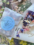 Larkspur Confetti 4g packet on a floral background with petals over a Wedding card