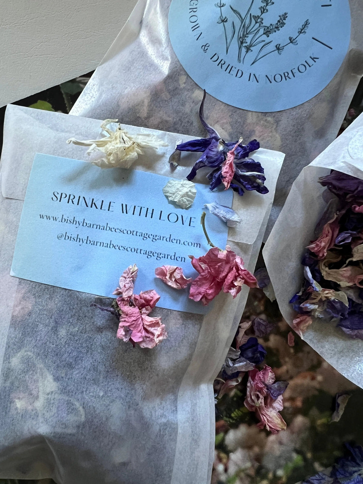 Larkspur Confetti – close-up of a packet of pink, purple and white petals with blue label