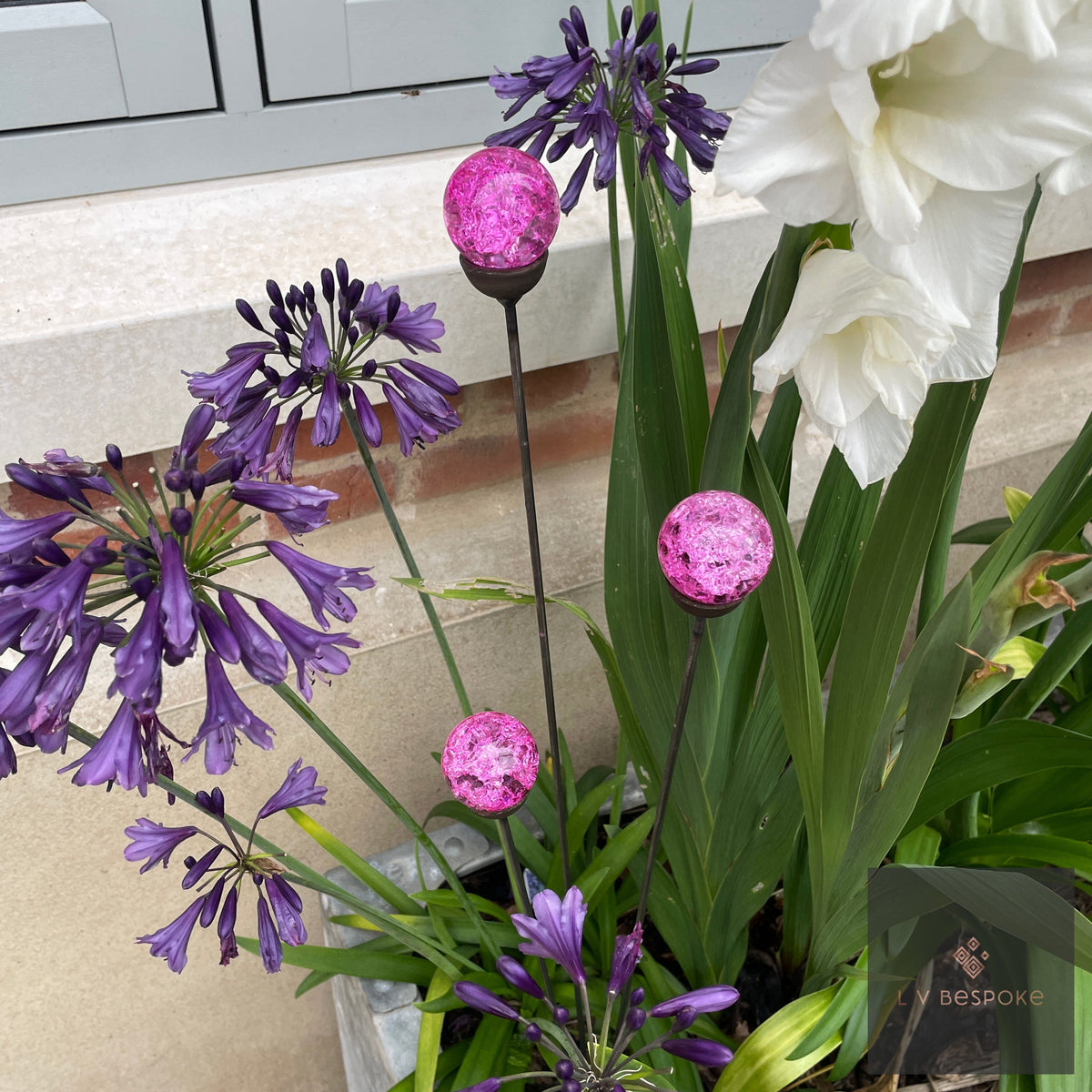 Glass Orb Cluster – pink orbs beside purple agapanthus and white lilies