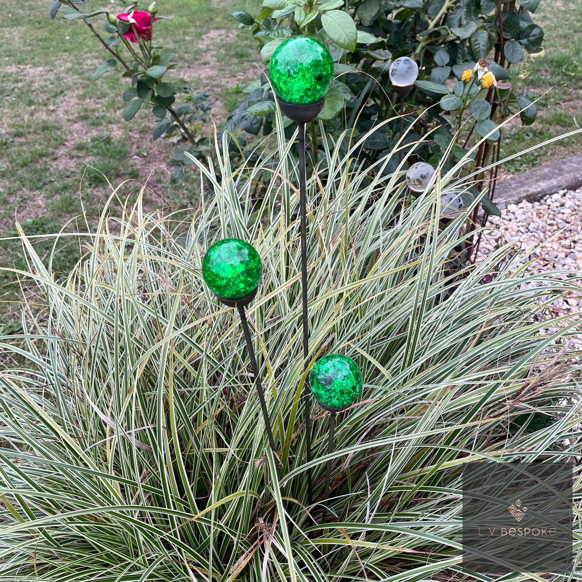 Glass Orb Cluster – green crackle-glass orbs above variegated ornamental grass