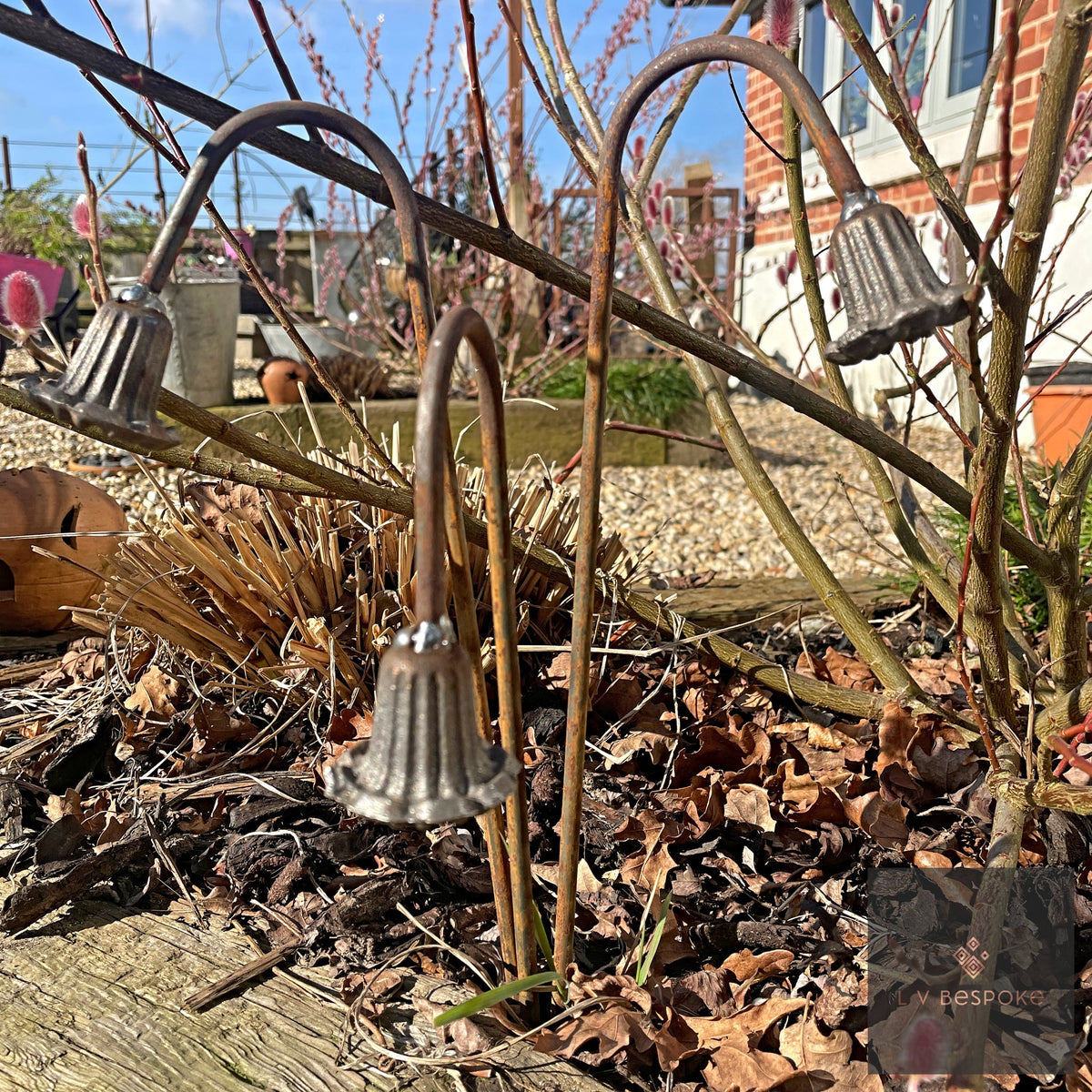 Short floral metal garden stakes – bell-flower stakes with curved stems in a winter border