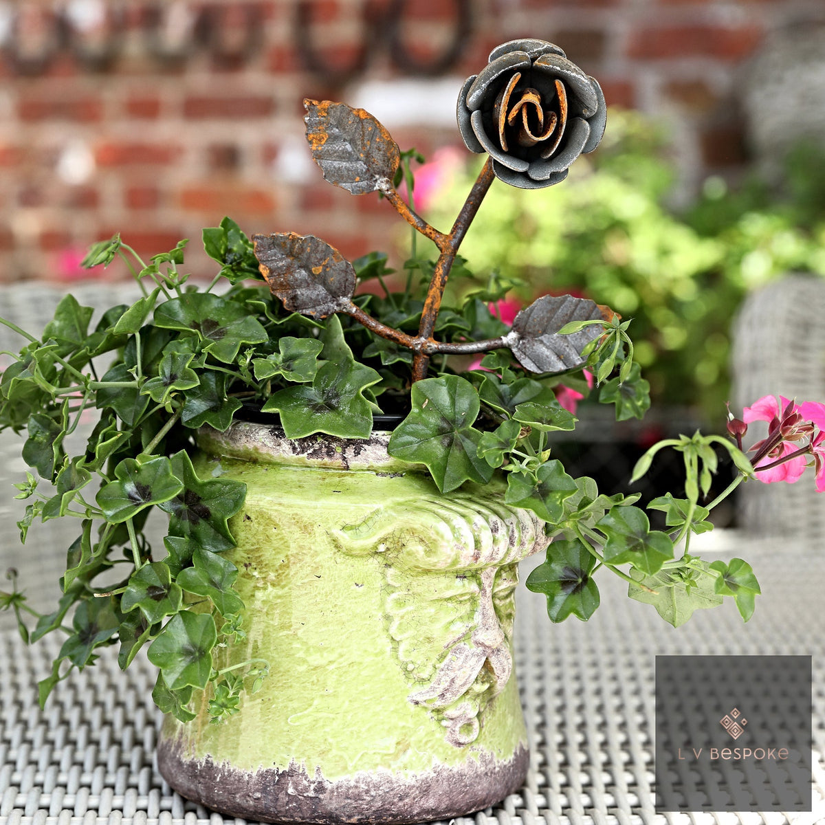 Short floral metal garden stake – metal rose in a lime-green pot of trailing plants