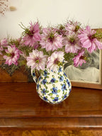 Ceramic jug of pale pink Nigella Mulberry Rose beside a framed black-and-white photo