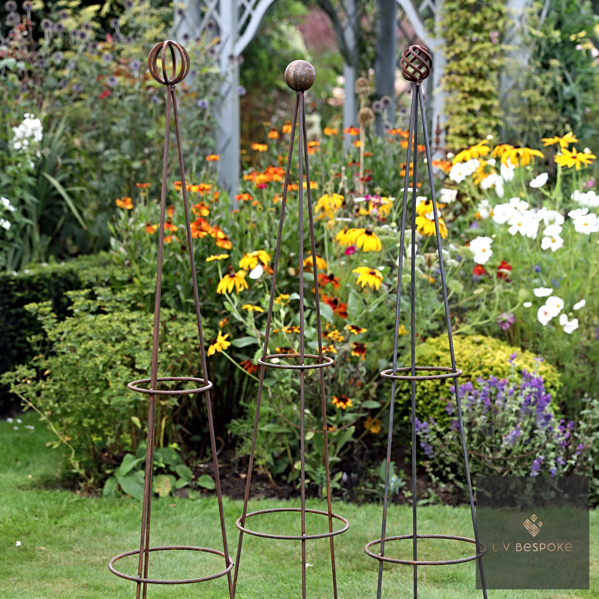 Obelisk Garden Feature – rusted metal obelisks in a flowering border
