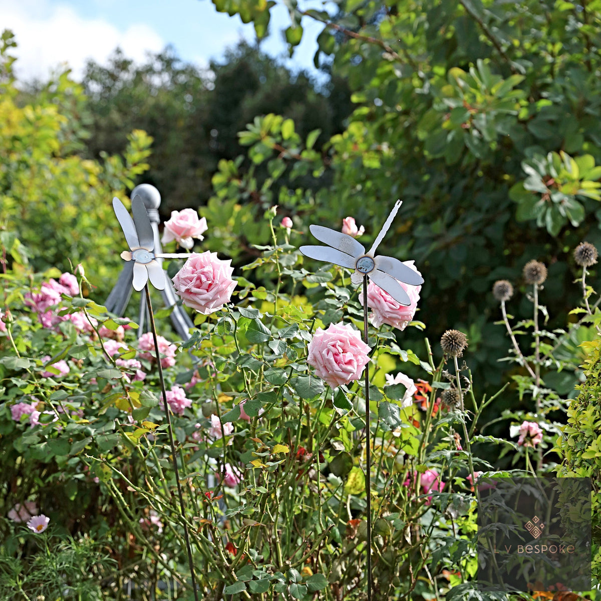 Swaying Garden Stakes – dragonflies above pink roses in a border