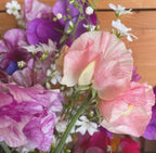 Sweet Pea Heaven Scent bouquet of pastel pink, purple and white flowers against wood
