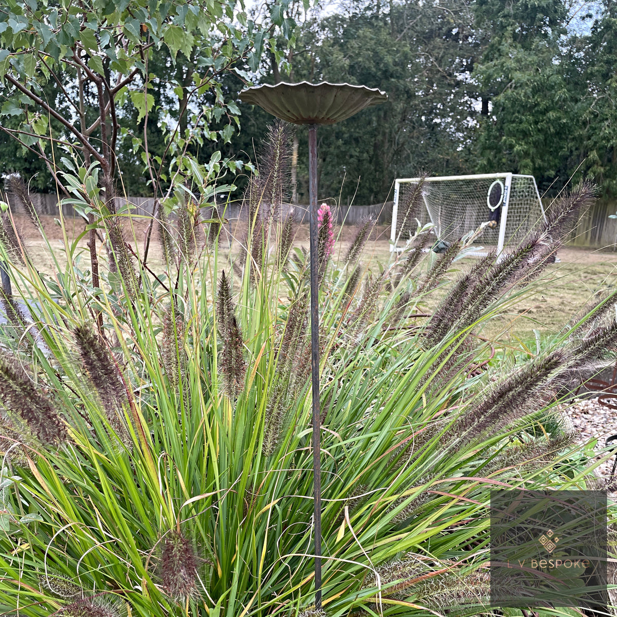 VIBee Bee Drinker standing tall behind ornamental grasses in a garden