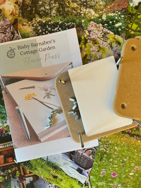 The Bishy Barnabees Cottage Garden Wooden Flower Press - Mini, complete with instructions and hardware, is shown atop colorful garden photos of blooming flowers and lush greenery.